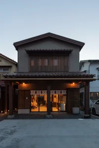 夕暮れに照明が灯る亀岡工務店A-UN会津若松展示場の外観・古材と漆喰の町屋造り